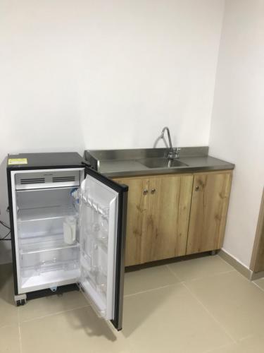 La cuisine est équipée d'un évier et d'un réfrigérateur ouvert. dans l'établissement "La casa de mi tia" Agradable, Acogedor, Tranquilo, à Envigado