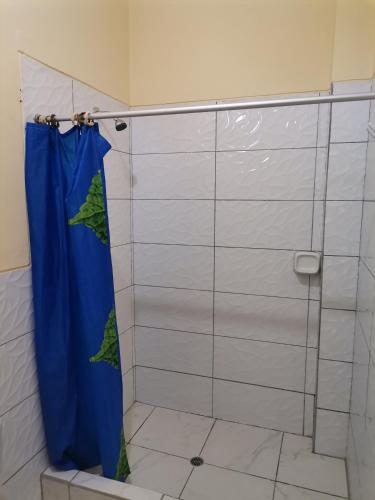 a shower with a blue shower curtain in a bathroom at Hospedaje Marvento in Pucallpa