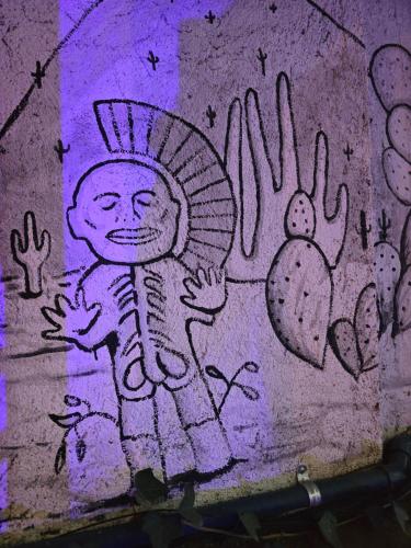 a wall with a painting of a person painted on it at Casa del Árbol Xochimilco in Oaxaca City