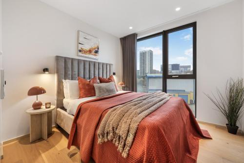a bedroom with a large bed with a large window at Luxury 2Bedroom 2Bath Coal Yard - Gym - Ac - Lift - 24h in London