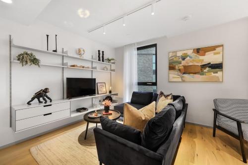 a living room with a couch and a tv at Luxury 2Bedroom 2Bath Coal Yard - Gym - Ac - Lift - 24h in London