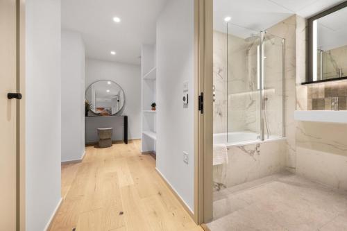 a white bathroom with a shower and a sink at Luxury 2Bedroom 2Bath Coal Yard - Gym - Ac - Lift - 24h in London