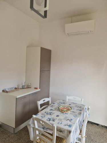 a kitchen with a table and a refrigerator at Casa Fuxia in Marina di Cecina