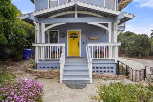 ein blaues Haus mit gelber Tür und Treppe in der Unterkunft Darling Del Mar Beach Cottage with Ocean Views in San Diego