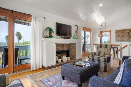ein Wohnzimmer mit Kamin und Fernseher in der Unterkunft Darling Del Mar Beach Cottage with Ocean Views in San Diego