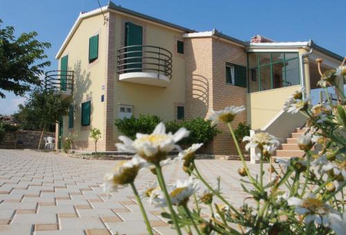 ein Haus mit Blumen davor in der Unterkunft Tolles Ferienhaus in Grohote mit Privatem Pool und Meerblick in Grohote