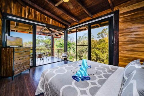 une chambre avec un lit dans une pièce avec des fenêtres dans l'établissement Oceanview And Private Pool 8 Mins To Downtown, à Hernández