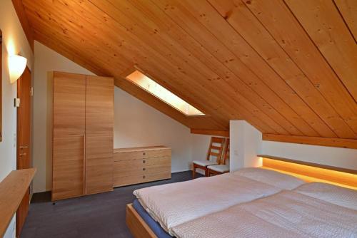 ein Schlafzimmer mit einem Bett und einer Holzdecke in der Unterkunft Chesa Filomela in Bever