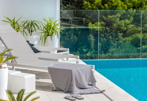 einen Pool mit weißen Liegestühlen neben einem Pool in der Unterkunft Ferienhaus mit Privatpool für 8 Personen ca 200 m in Veliko Brdo, Dalmatien Biokovo-Gebirge in Veliko Brdo