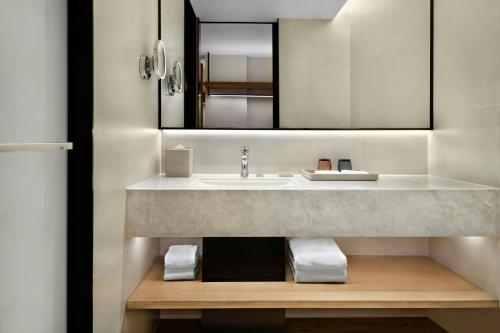 une salle de bain avec un lavabo et un miroir dans l'établissement Fairfield by Marriott Shanghai Xuhui Center, à Shanghai