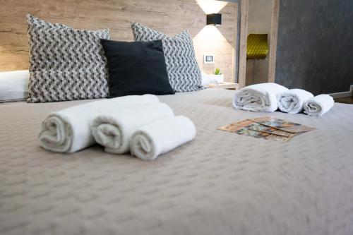 a group of towels on a white bed at Casa Catone (affitta camere) in Monte Porzio Catone