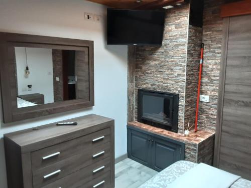 a bedroom with a fireplace and a tv on a brick wall at RUBYAi in Icod el Alto