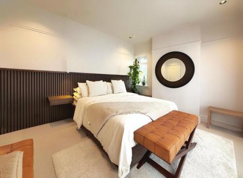 ein Schlafzimmer mit einem großen Bett und einem Spiegel in der Unterkunft High Tree - Stylish Detached Home - South Park and Town Centre in Macclesfield