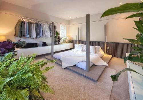 ein Schlafzimmer mit Himmelbett und Kleiderständern in der Unterkunft High Tree - Stylish Detached Home - South Park and Town Centre in Macclesfield