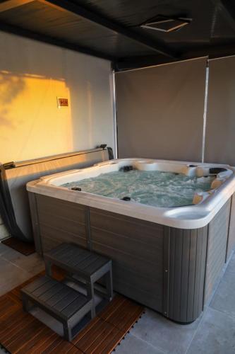 a jacuzzi tub with a stair in a room at Hacijenda in Vukovar
