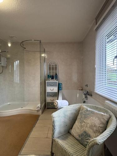 Un baño con sofá, ducha y bañera. en Spacious Two-Bedroom Guest Suite, Exmouth, en Lympstone