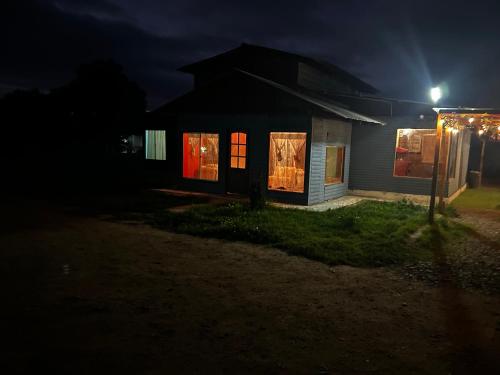 una casa por la noche con luces en las ventanas en Blue Tavern House, en Vallenar