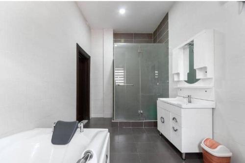 a white bathroom with a shower and a sink at 3 bedroom Masionette in Lekki