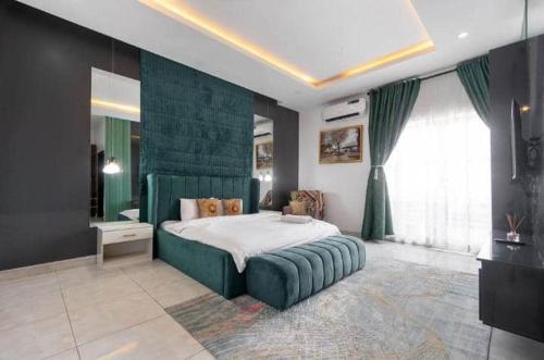 a bedroom with a large bed with a green headboard at 3 bedroom Masionette in Lekki