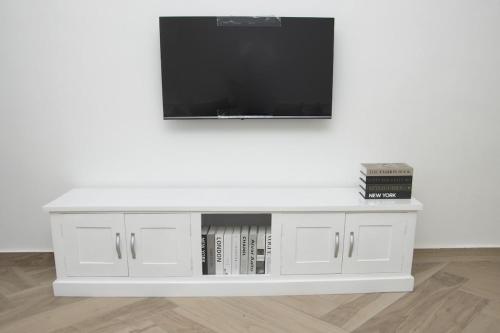 - un centre de divertissement blanc avec une télévision dans l'établissement Zeitahomes, à Cotonou