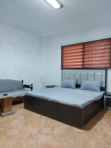 a bedroom with a large bed and a bench at Stone house in Amman