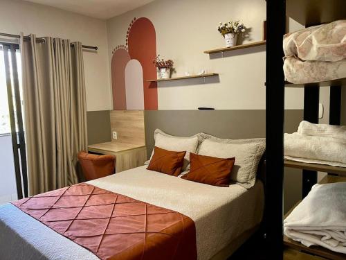 a bedroom with a bed and two bunk beds at Kitnet no centro com garagem in Caxias do Sul