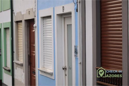 een rij ramen met luiken op een gebouw bij Cantinho da Bea I in Angra do Heroísmo