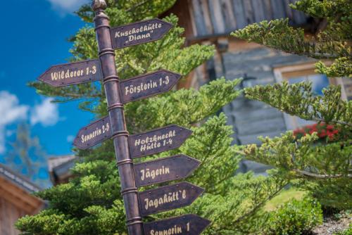 a pole with street signs in front of a tree at Almwelt Austria in Schladming