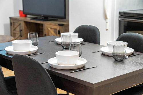 einen Tisch mit Tellern und Weingläsern darauf in der Unterkunft The Arizona 2BR Pet-Friendly Suite Calgary SE in Calgary