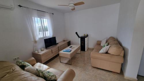 Una sala de estar con dos sofás y un televisor de pantalla plana. en Casa Bella - 2 Bedroom Villa - Arboleas, en Arboleas