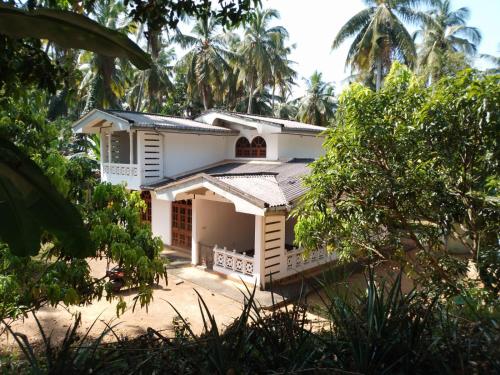 a white house with trees in front of it at House for rent in Mirigama, Sri Lanka in Mirigama