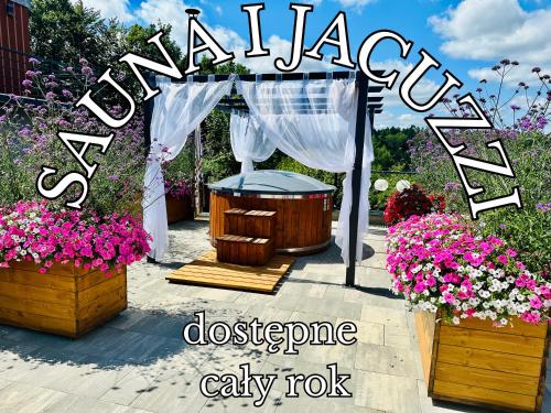 a garden scene with a gazebo and flowers at Gackowo in Ostróda