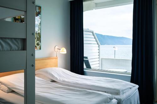 a bedroom with a bed and a view of the ocean at Balestrand Hotel in Balestrand