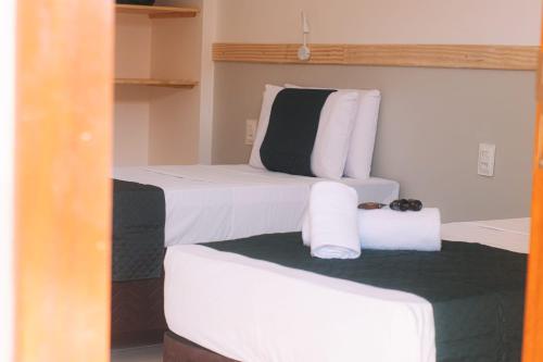 - 2 lits dans une chambre avec des draps blancs et des serviettes dans l'établissement São João Paulo II - Casa de Retiro, à Aquiraz