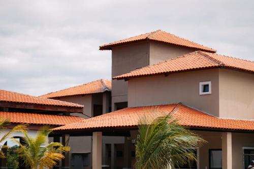 une rangée de maisons aux toits de tuiles orange dans l'établissement São João Paulo II - Casa de Retiro, à Aquiraz