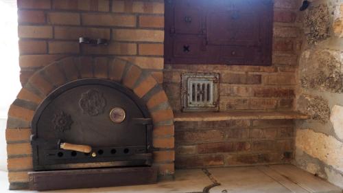 a brick oven with a door on a wall at Lera de cal roger in Verdú