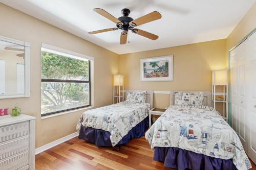 una camera da letto con due letti e un ventilatore a soffitto di Waterfront condo with community pools & hot tub - walk to the beach a St. Augustine