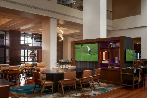 a dining room with a television and tables and chairs at Kansas City Marriott Downtown in Kansas City