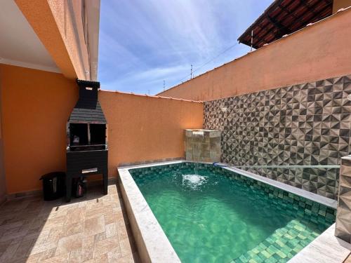 uma grande piscina com lareira em uma casa em Casa de condomínio com piscina e churrasqueira em São Paulo