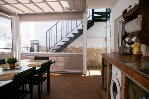une cuisine avec une table et des chaises ainsi qu'un escalier dans l'établissement Casa María en el centro Nerja, à Nerja
