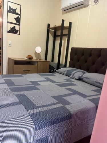 ein Schlafzimmer mit einem Bett mit einer blau karierten Decke in der Unterkunft Casinha na serra para até 4 pessoas in Nova Petrópolis