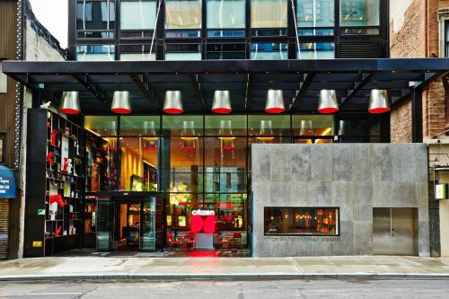 Un edificio con luces rojas y blancas en una ciudad. en citizenM New York Times Square, en Nueva York