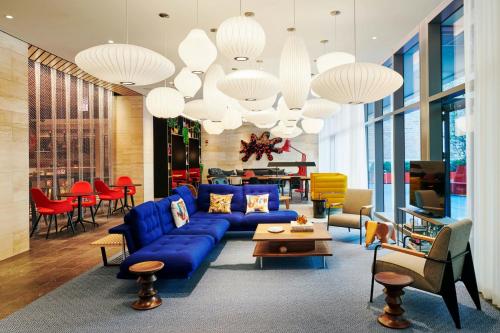 a living room with a blue couch and chairs at citizenM Chicago Downtown in Chicago
