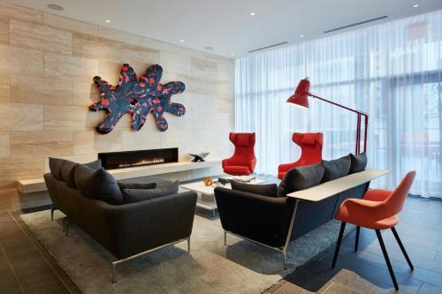 a living room with red chairs and a fireplace at citizenM Chicago Downtown in Chicago