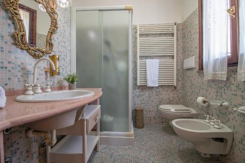 ein Badezimmer mit Waschbecken, Toilette und Dusche in der Unterkunft Villa Ferrara Royal Resort & Spa in Coriano