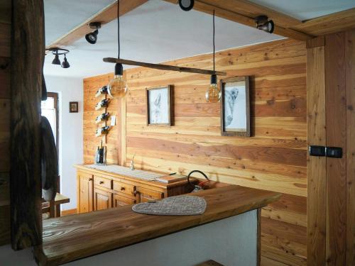 eine Küche mit Holzwänden und einer Theke mit Beleuchtung in der Unterkunft Stone Cabin With Views Over Balme Valley in Alo di Stura