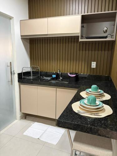 una cucina con un bancone con piatti e un lavandino di Flats do Vale 2 a Petrolina
