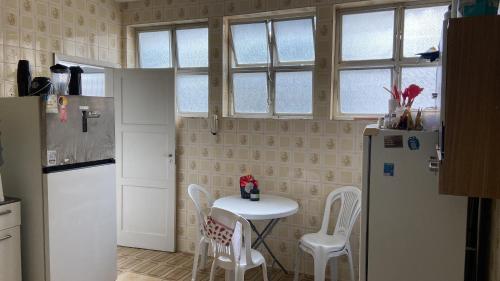 een keuken met een tafel, stoelen en een koelkast bij Apartamento na Pituba in Salvador