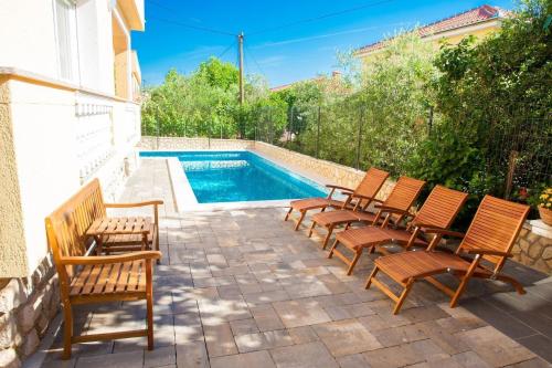 a group of chairs sitting next to a swimming pool at Pension Tina App 1 in Šilo