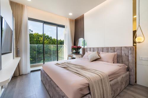 ein Schlafzimmer mit einem großen Bett und einem großen Fenster in der Unterkunft Luxury 3BR Apartment 121m - Resort Pool & Gym - Near Aeon Mall in Ho-Chi-Minh-Stadt